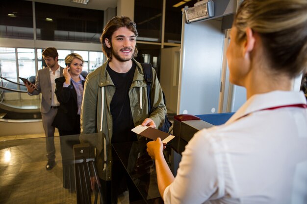 Homme en file d'attente recevant un passeport et une carte d'embarquement