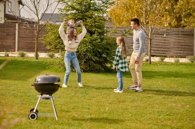 Photo gratuite homme et fille regardant une femme avec un enfant sur le cou