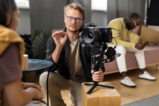 Photo gratuite homme filmant avec une caméra professionnelle pour un nouveau film