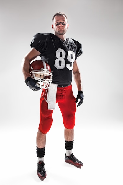 Homme de fitness caucasien en tant que joueur de football américain sur fond blanc