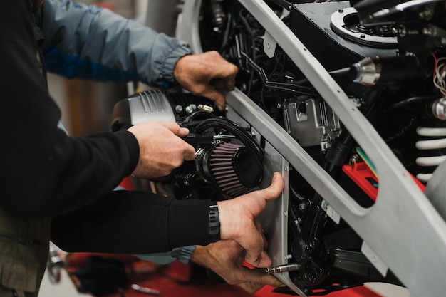 Homme fixant une moto dans un atelier moderne