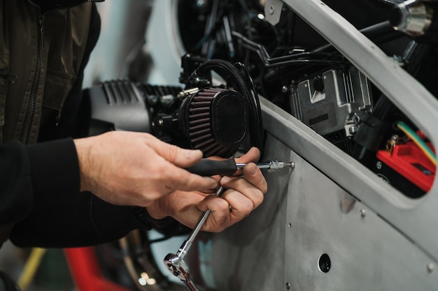 Homme fixant une moto dans un atelier moderne