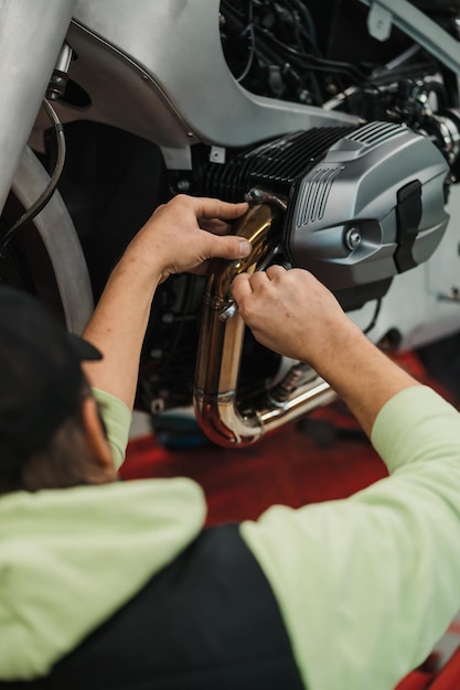 Photo gratuite homme fixant une moto dans un atelier moderne