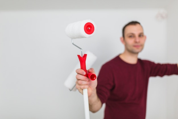 Homme flou avec des rouleaux de peinture