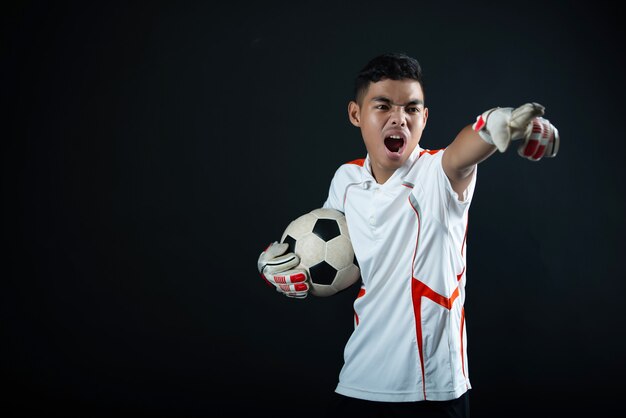 Homme de football jeune gardien isolé de l'équipe de football de l'Académie