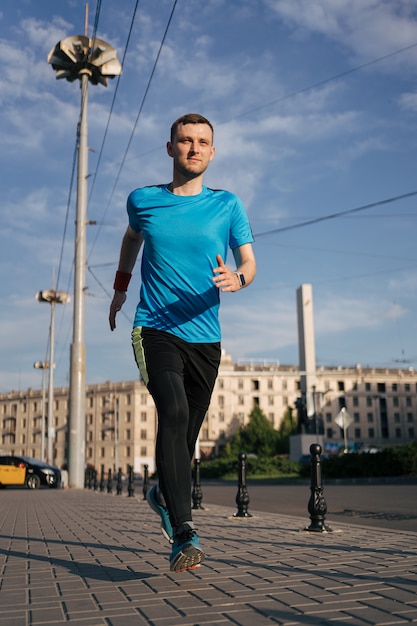 Homme en forme attrayant courir dans la ville