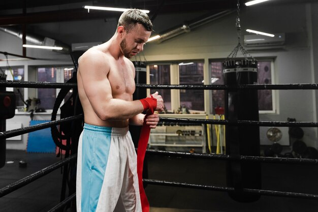 Homme fort s'apprête à s'entraîner sur le ring de boxe