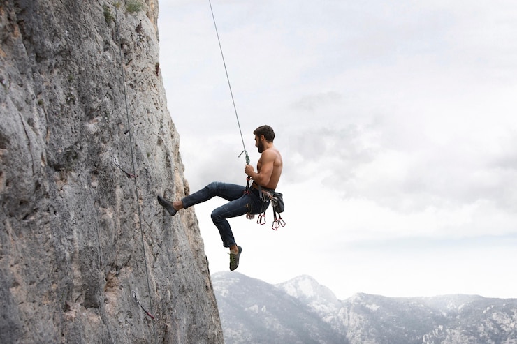 Photo gratuit homme fort s'élevant sur une montagne avec l'équipement de sécurité