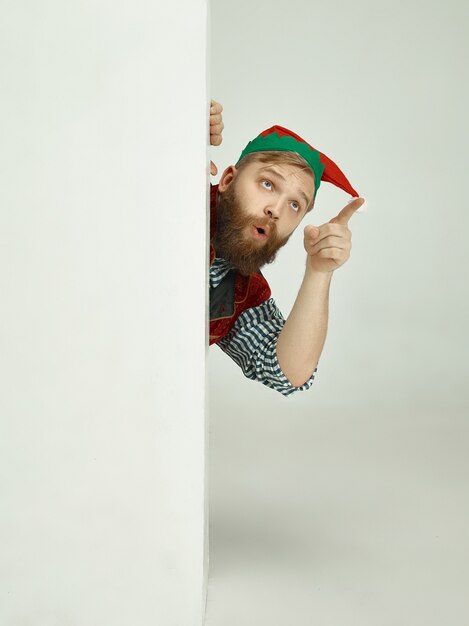 Homme gai en costume d'elfe pointant quelque chose avec son doigt