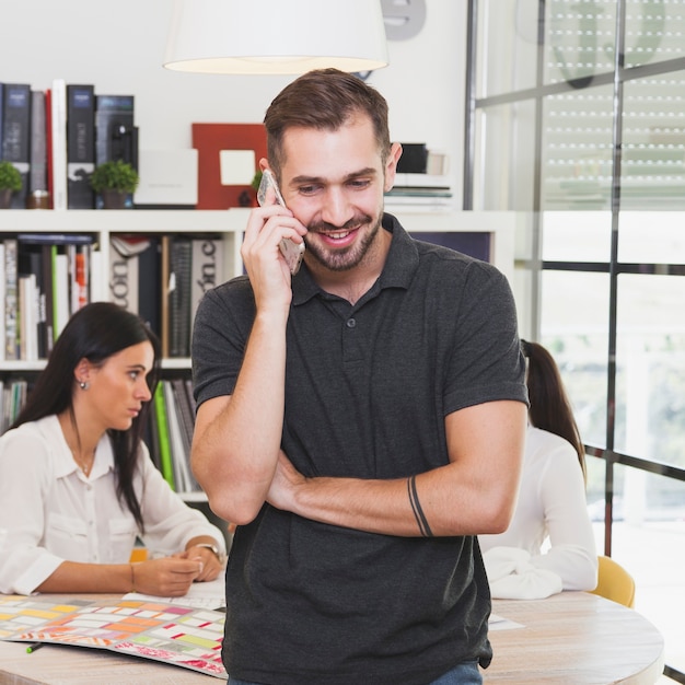 Homme gai, parler sur smartphone au bureau