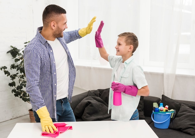 Homme et garçon se tiennent à cinq pour le nettoyage