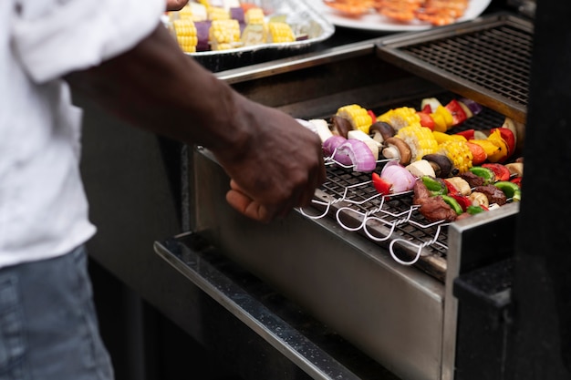 Homme grand angle faisant un barbecue