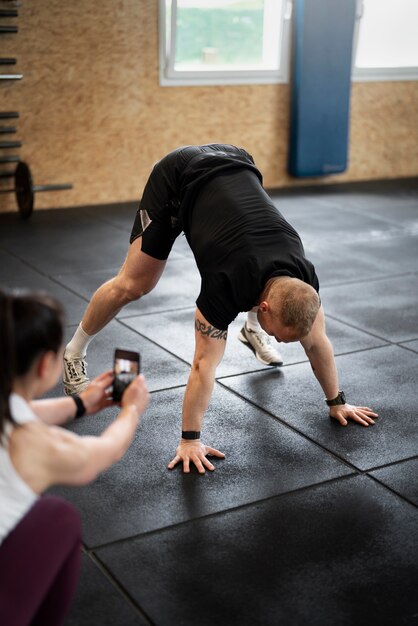 Homme grand angle faisant des burpees