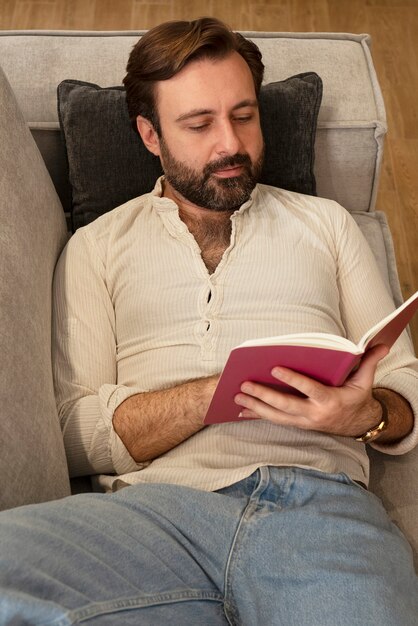 Photo gratuite homme grand angle lisant à la maison
