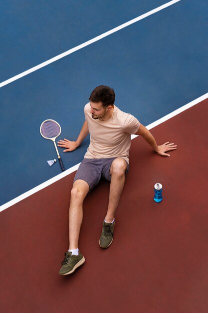 Homme grand angle sur le terrain de badminton