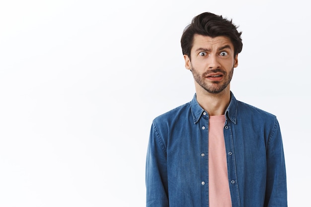 homme, grincer des dents à cause de quelque chose de dégoûtant ou d'affreux, grimaçant alarmé, fronçant les sourcils rend une expression troublée et frustrée