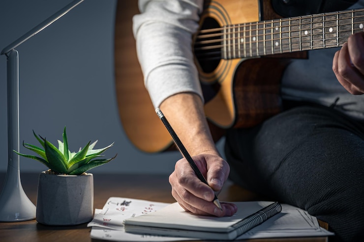 Photo gratuit un homme avec une guitare crée des pièces de musique la nuit