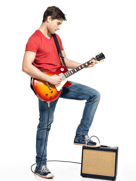 L'homme guitariste joue à la guitare électrique avec des émotions vives, isoler sur blanc