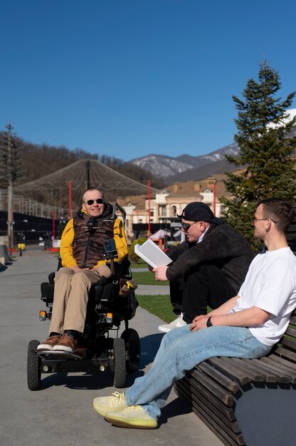 Homme handicapé avec des amis à l'extérieur plein coup