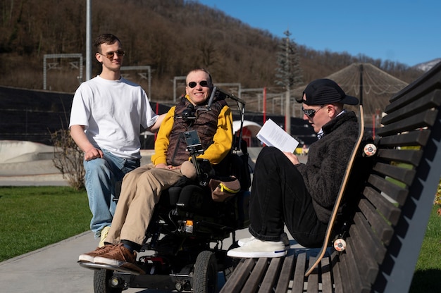 Photo gratuite homme handicapé avec des amis à l'extérieur plein coup