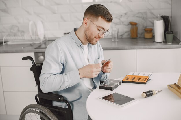 Homme handicapé en fauteuil roulant comme la réparation. Rester à la maison, passe-temps.