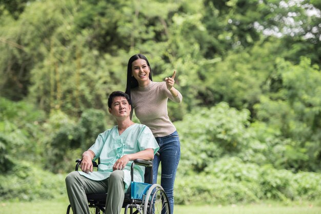 Homme handicapé en fauteuil roulant et sa petite amie dans le parc