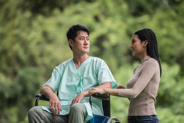 Homme handicapé en fauteuil roulant et sa petite amie dans le parc