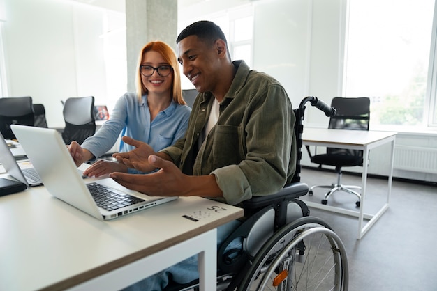 Homme handicapé en fauteuil roulant travaillant à son travail de bureau
