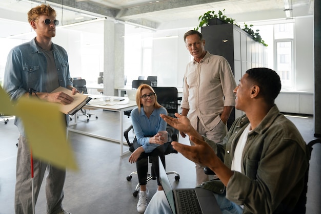 Photo gratuite homme handicapé en fauteuil roulant travaillant à son travail de bureau