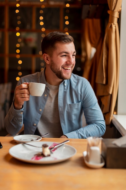 Homme heureux au restaurant, boire du café