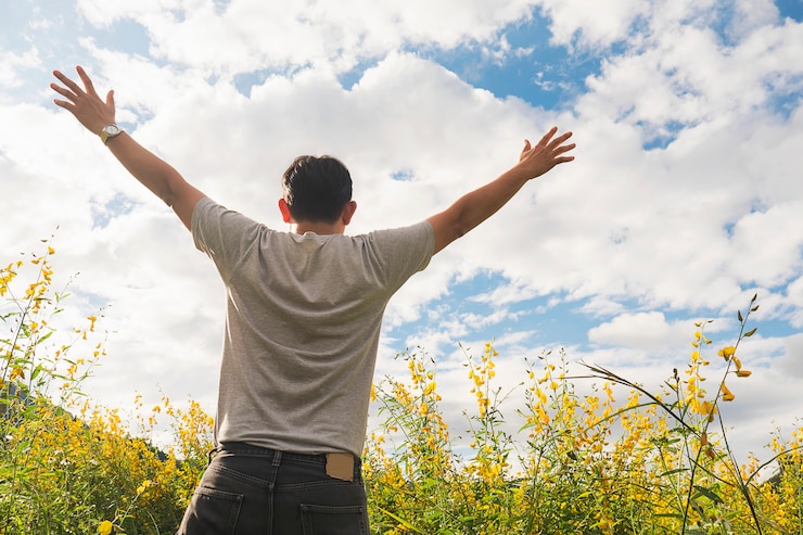 Photo gratuit homme heureux dans la nature de la fleur de champ jaune et nuage blanc ciel lumineux