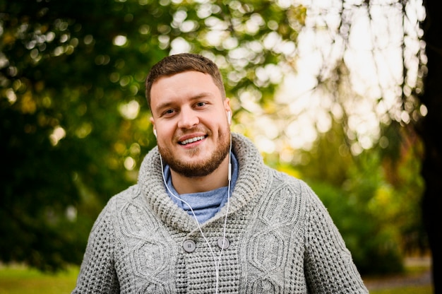 Homme heureux avec des écouteurs, souriant à la caméra