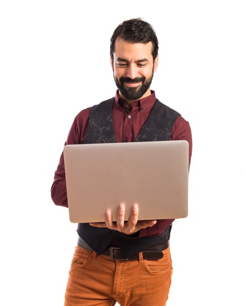 Homme heureux portant un gilet avec un ordinateur portable