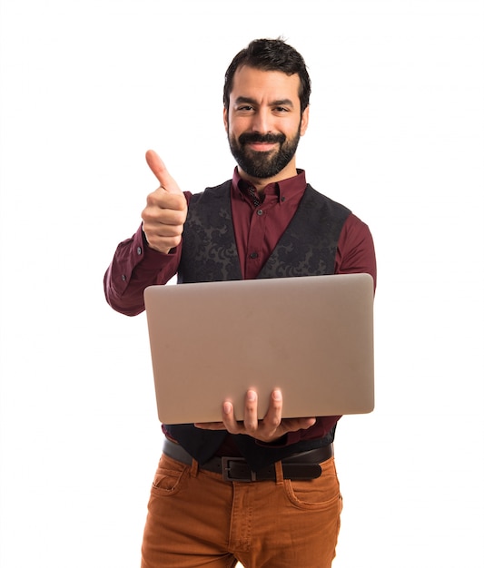 Homme heureux portant un gilet avec un ordinateur portable