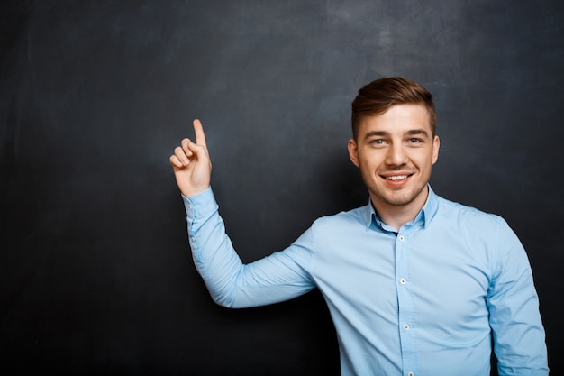 homme heureux sur le tableau noir avec un fond de doigt