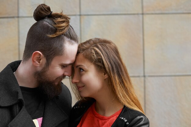 Homme hipster barbu serrant sa petite amie pendant la marche