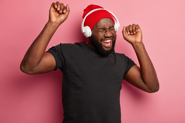 Homme hipster écoute de la musique dans des écouteurs sans fil isolés