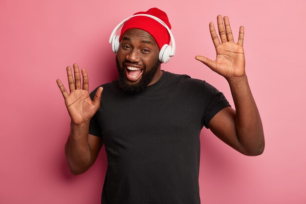 Homme hipster écoute de la musique dans des écouteurs sans fil isolés