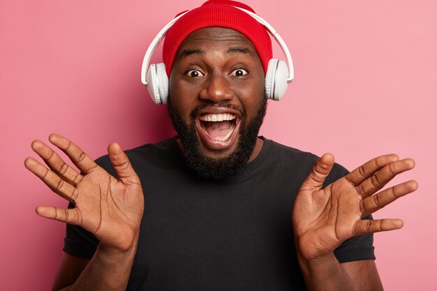 Homme hipster écoute de la musique dans des écouteurs sans fil isolés