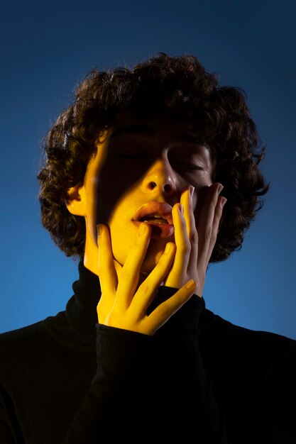 Homme inconnu à faible angle posant à la lumière jaune