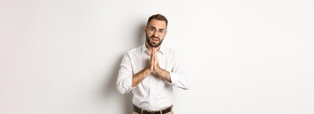 Homme inquiet demandant de l'aide implorant une faveur debout sur fond blanc