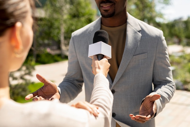 Homme interviewé par des journalistes à l'extérieur