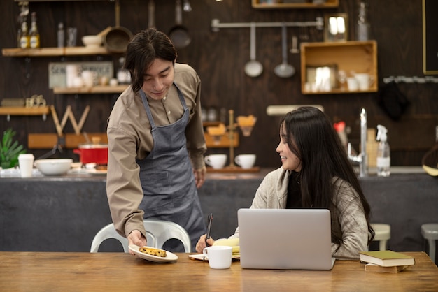 Homme japonais servant de la nourriture au client dans un restaurant