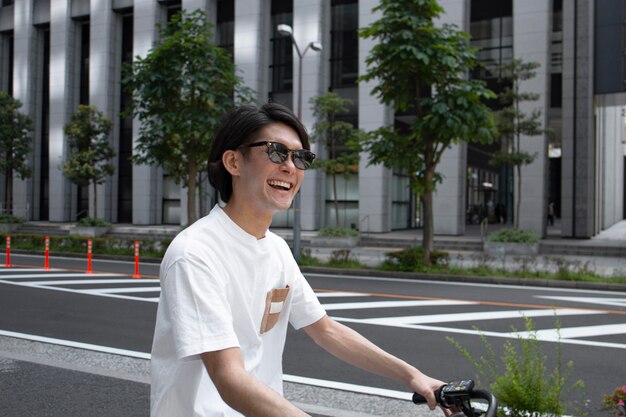 Homme japonais avec son vélo à l'extérieur