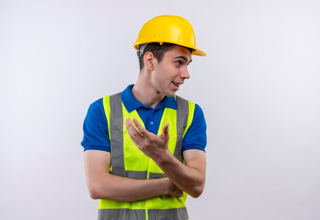 Homme jeune constructeur portant l'uniforme de construction et un casque de sécurité demande