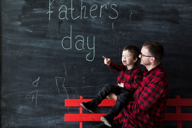 Homme avec jeune fils le jour du père devant le tableau