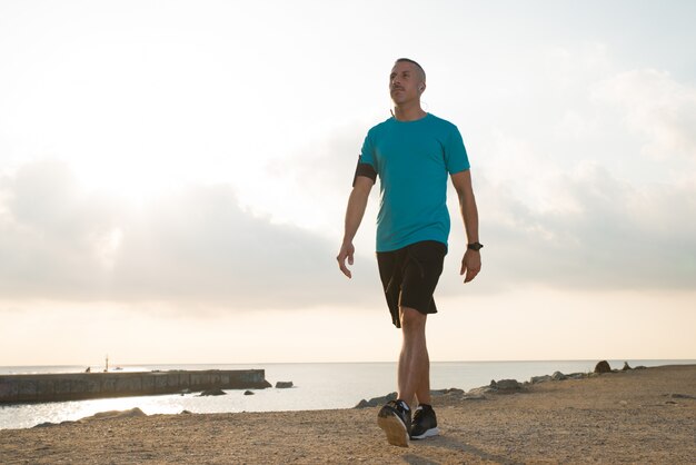 Homme de jogging confiant qui marche après avoir couru