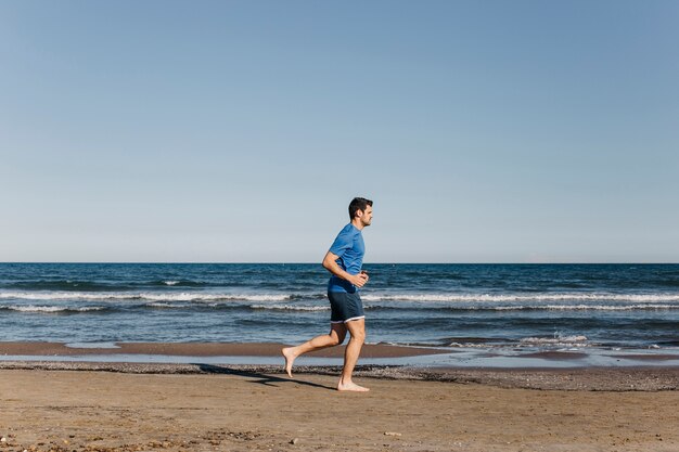 Homme jogging à la plage