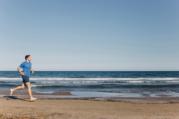 Homme jogging à la plage