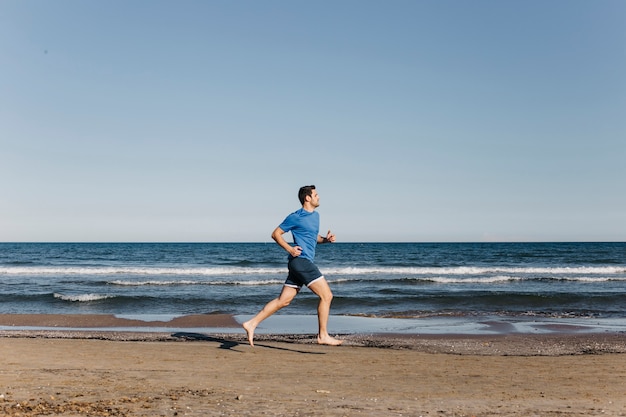 Homme jogging à la plage